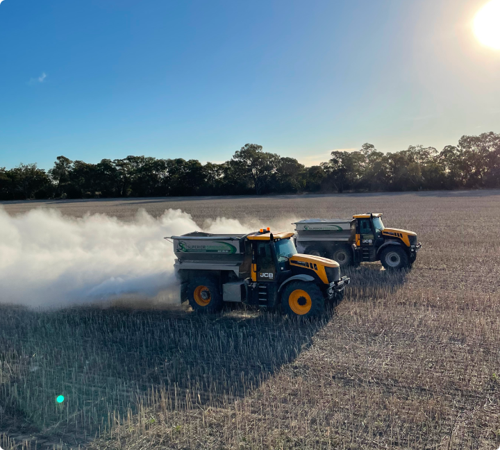 Two tractors spraying a field with smoke, applying granulated fertiliser and lime for precise agricultural management.